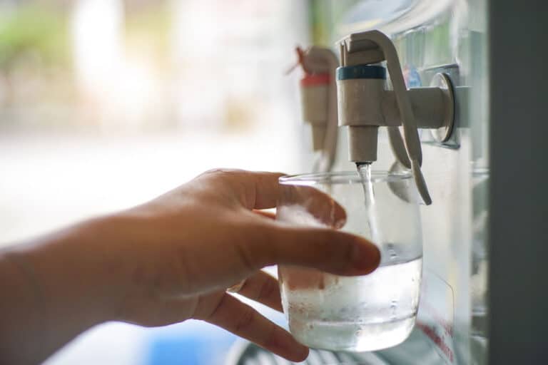 Man Pouring A Glass Of Water From A Water Cooler