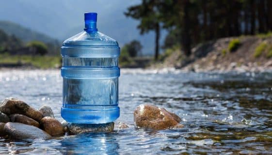Bottle of Spring Water in An Ice Box Bulk Water Container Sitting on Rocks in Spring — Spring Water Online in Agnes Water, QLD