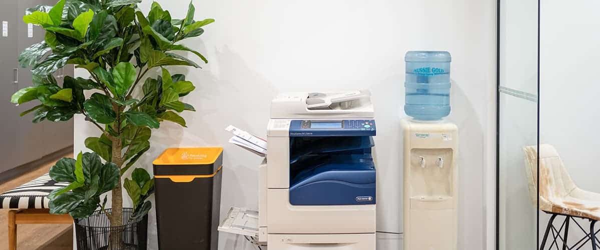 Water dispenser beside photocopy machine — Spring Water Supplier in Yeppoon, QLD