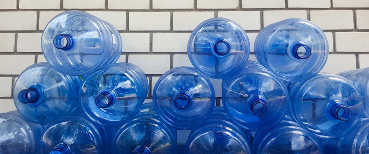 Stacked Empty Water Cooler Bottles — Spring Water Online in Emerald, QLD
