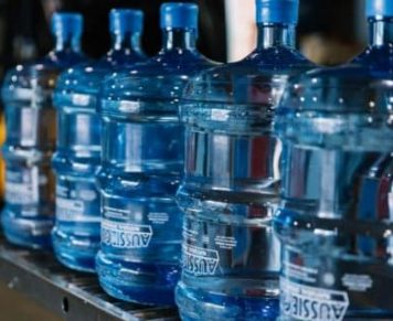 Gallons Of Spring Water Lined Up On A Table — Spring Water Online in Gracemere, QLD